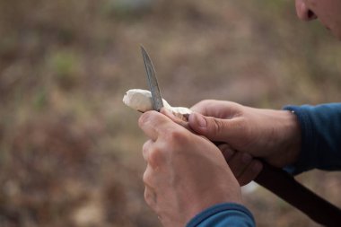 Bir tahta kaşık oyma bir bıçak ile çalışan adamın elleri uygun.