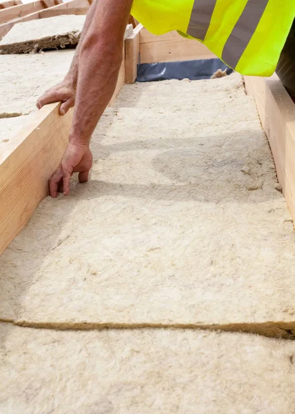 Roofer builder arbetstagare installera taket isoleringsmaterial på nytt hus under uppförande. — Stockfoto