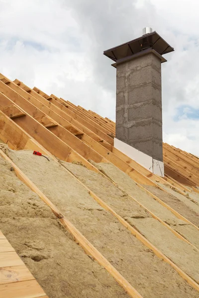 Isolamento del tetto (lana di roccia). Nuova casa in costruzione con camino . — Foto Stock