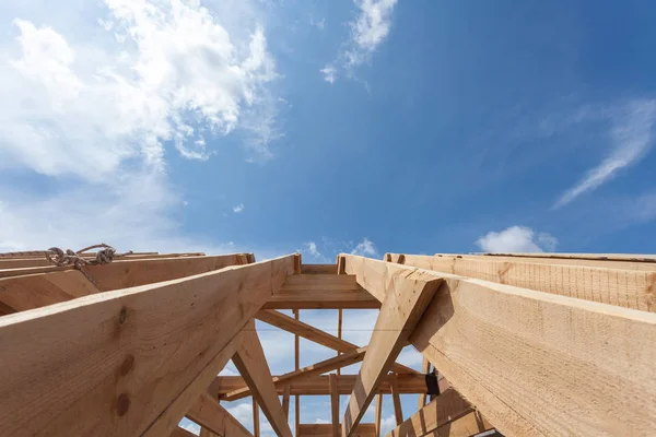 Nuova costruzione residenziale in legno casa incorniciatura contro un cielo blu . — Foto Stock