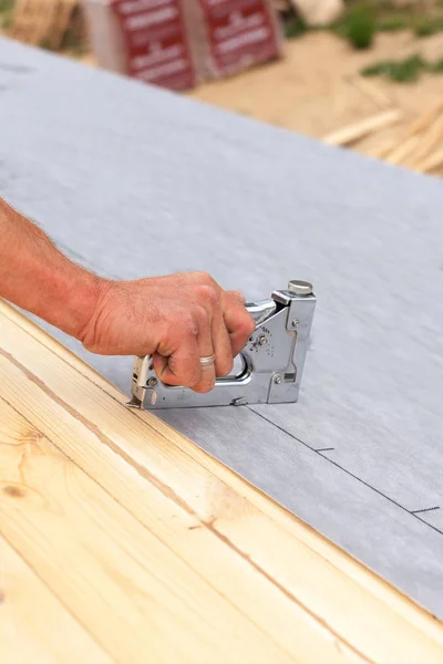 Roofer naglar foder använder konstruktion häftapparat. Tak under konstruktion. — Stockfoto