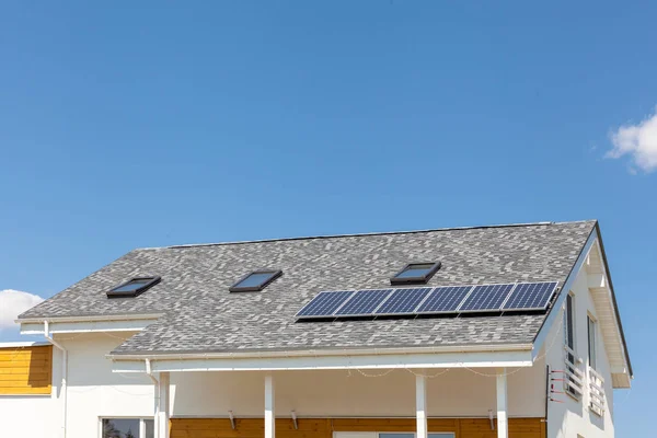 Солнечная водяная панель отопления на крыше нового дома с люками против голубого неба . — стоковое фото