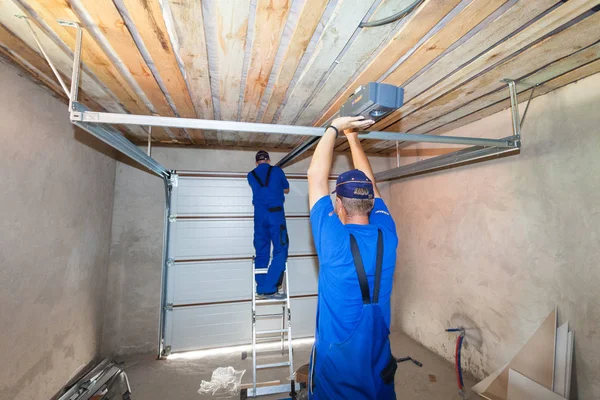 Installazione porte garage. Lavoratori che installano sistema di sollevamento  . — Foto Stock