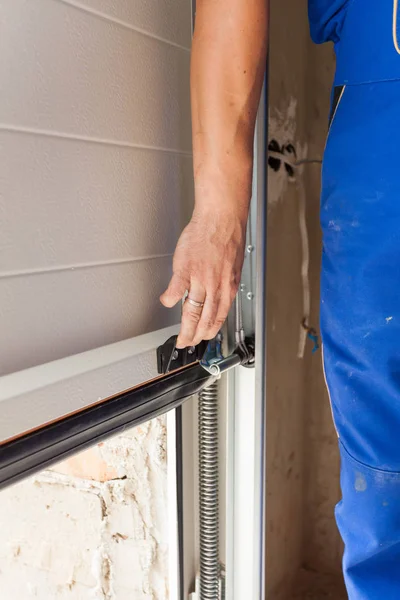 Operaio aprire una porta del garage durante l'installazione . — Foto Stock