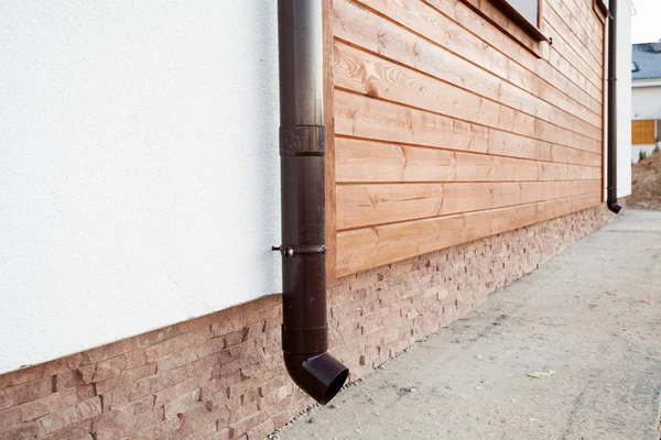 Nouvelle gouttière en cuivre brun dans la maison avec mur blanc et planches en bois . — Photo