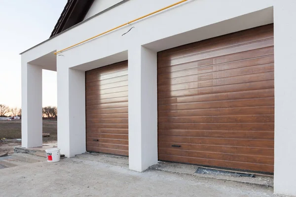 Puerta de garaje marrón doble en una casa nueva . — Foto de Stock