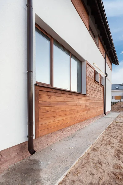 Nouvelle gouttière en cuivre brun dans la maison avec mur blanc et planches en bois . — Photo