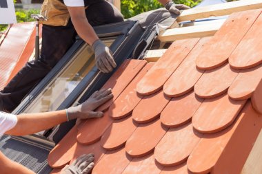 Çatı kiremit Çatı döşeme elleri. Doğal kırmızı kiremit yükleme. Çatı mansard windows ile