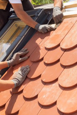 Çatı kiremit Çatı döşeme elleri. Doğal kırmızı kiremit yükleme. Çatı mansard windows ile