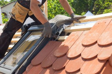 Çatı kiremit Çatı döşeme elleri. Doğal kırmızı kiremit pense kullanarak yükleme. Çatı mansard windows ile