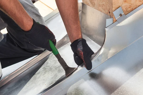 Roofer builder arbetare efterbehandling vika ett metall med special tång med en stor platt grip. — Stockfoto