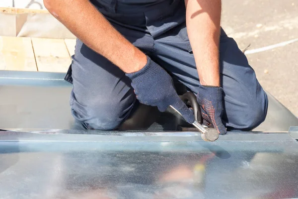 Çatı ustası Oluşturucusu alt lastik tokmak kullanarak bir sac katlama bitirme.