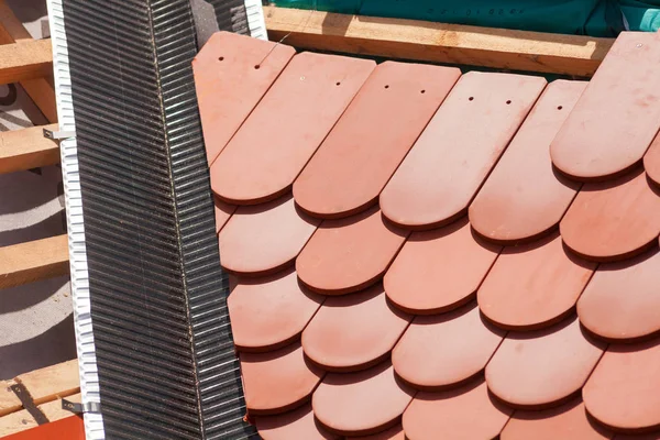 Nuevo techo en construcción con vigas de madera, capa de impermeabilización para esquina y baldosas naturales . — Foto de Stock