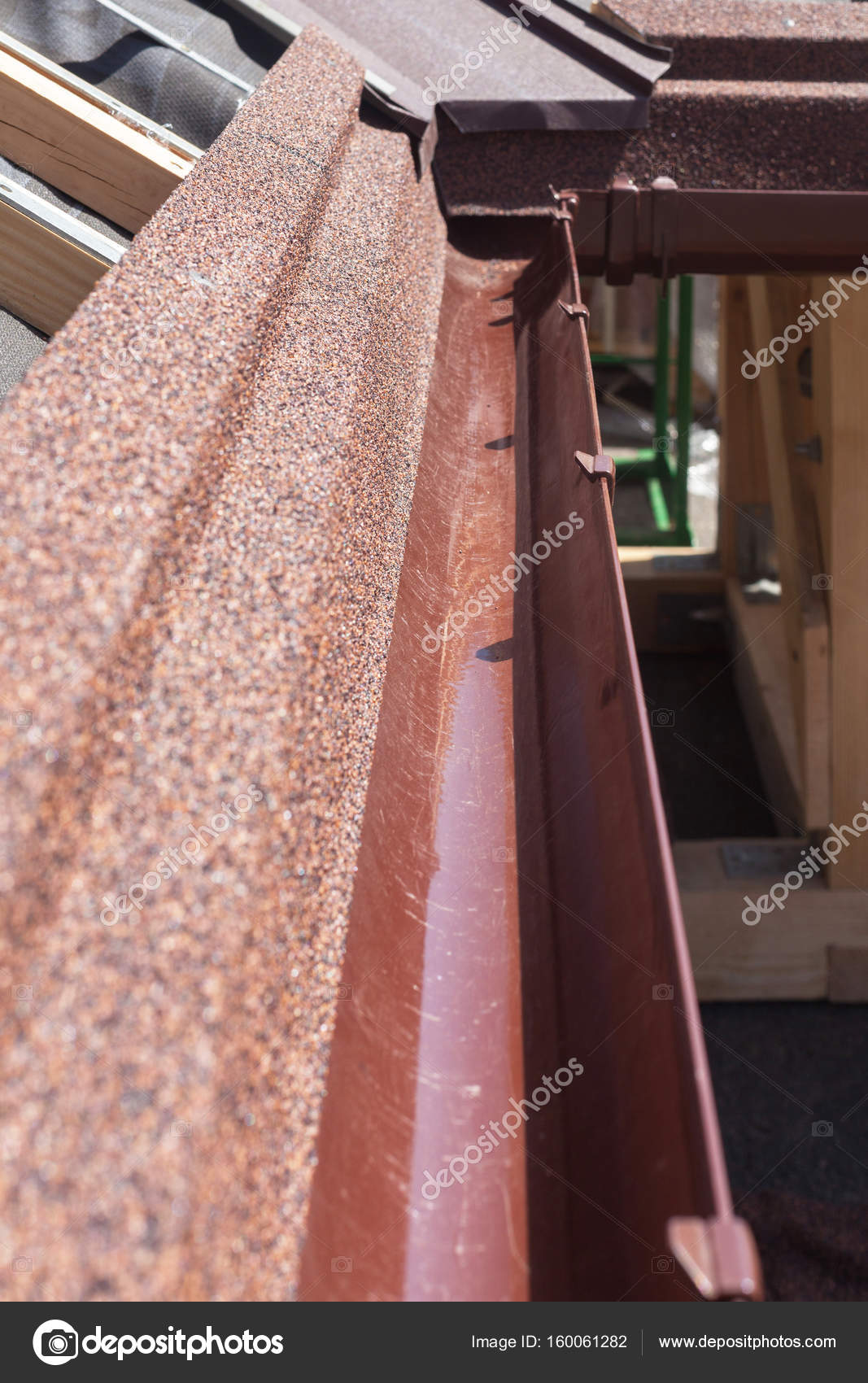 New asphalt shingle roof with brown rain gutter, wooden beams and