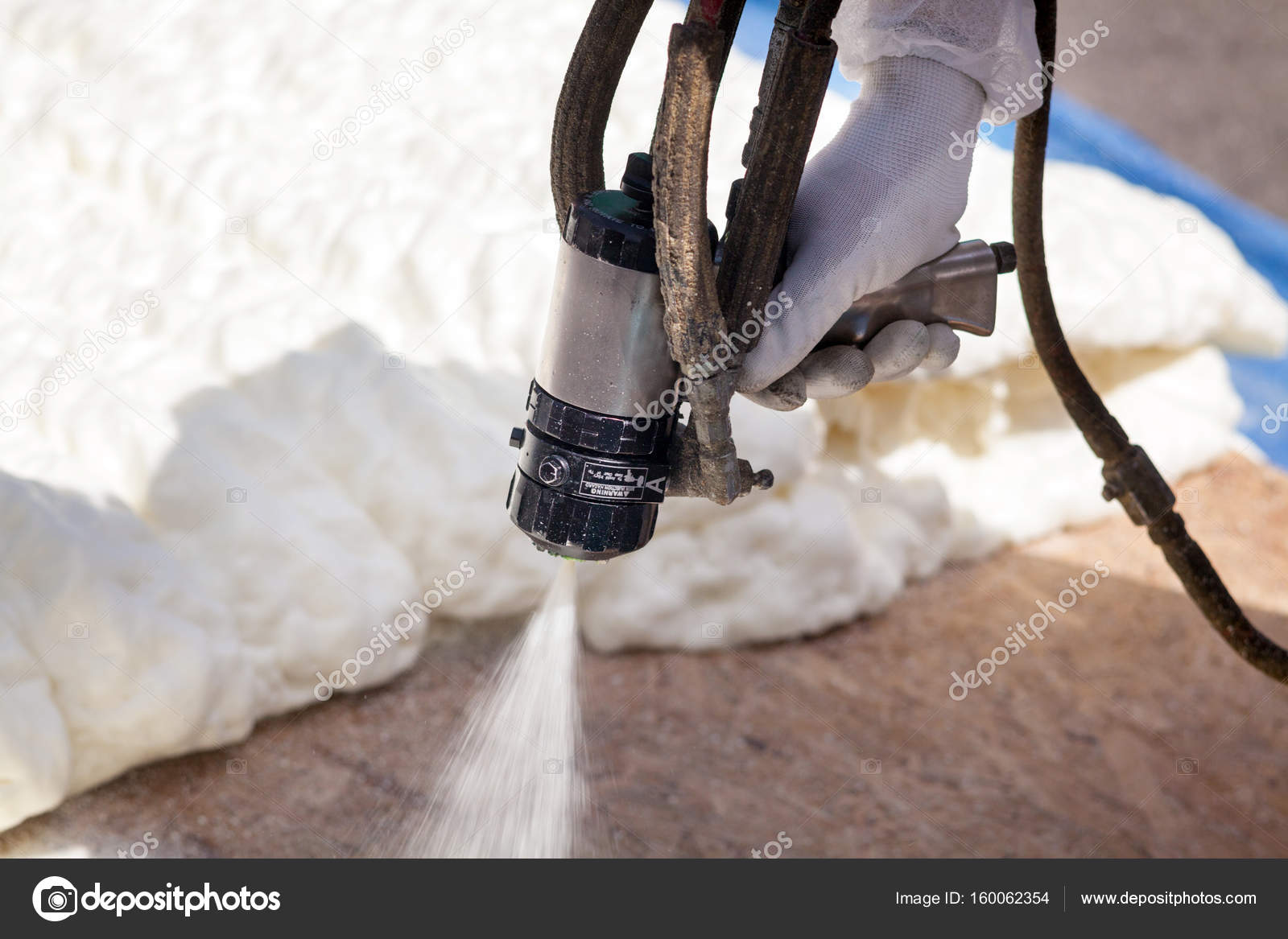 Technician spraying foam insulation using Plural Component Spray Gun