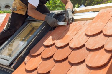 Doğal Çatı döşeme instaalation. Çatı ustası Oluşturucusu alt çini arasındaki mesafeyi ölçmek için ruller kullanın. Çatı mansard windows ile
