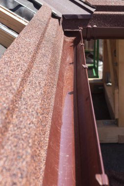 Yeni asfalt shingle çatı kahverengi yağmur oluk, ahşap kirişler ve Buhar denetim katmanı.