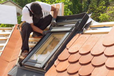 Kırmızı kiremit yeni bir çatı üzerinde mansard windows yüklemesi.