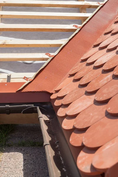 Nieuw dak in aanbouw met houten balken, waterproofing laag voor hoek en natuurlijke tegel. — Stockfoto