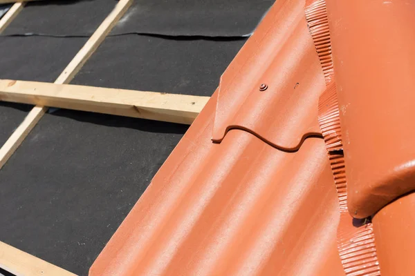 Novo telhado em construção com vigas de madeira, camada de impermeabilização para canto e telha natural . — Fotografia de Stock