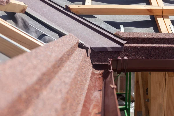 新しいアスファルト鉄片屋根は茶色の雨樋、木製の梁、蒸気制御層. — ストック写真