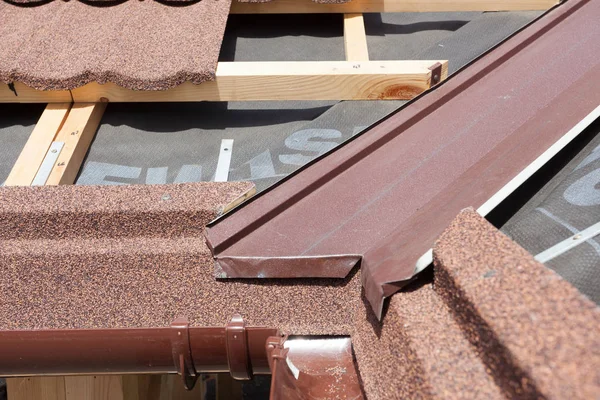 New asphalt shingle roof with brown rain gutter, wooden beams and vapour control layer. — Stock Photo, Image