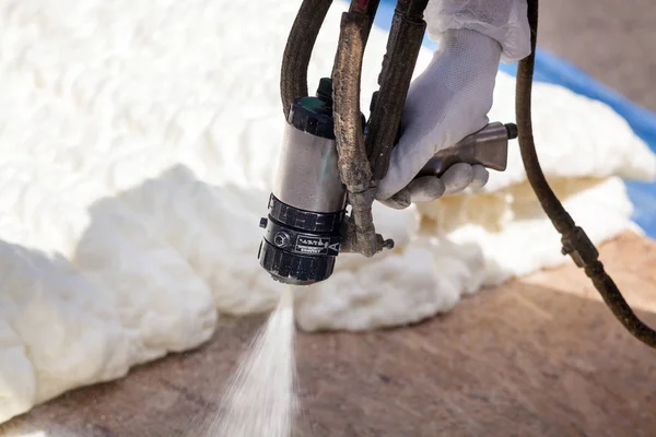 Technician spraying foam insulation using Plural Component Spray Gun. — Stock Photo, Image