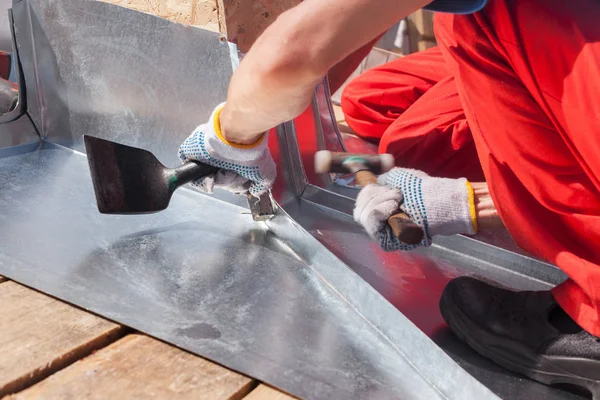 Ouvrier constructeur de toiture finition pliage d'une feuille de métal à l'aide de maillet en caoutchouc . — Photo