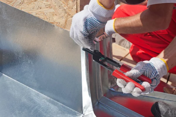 Roofer builder arbetare efterbehandling vika ett metall med special tång med en stor platt grip. — Stockfoto