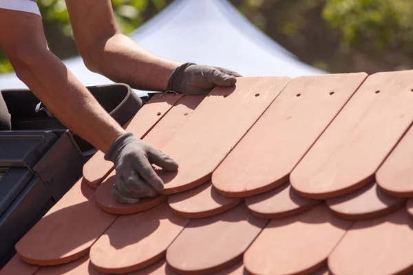 Hands of roofer laying tile on the roof. Installing natural red tile — Stock Photo, Image