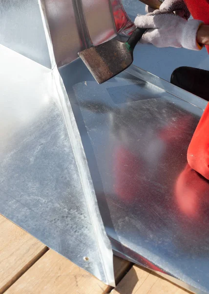 Çatı ustası Oluşturucusu alt lastik tokmak kullanarak bir sac katlama bitirme.