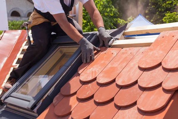 Manos de tejado colocando baldosas en el techo. Instalación de azulejos rojos naturales — Foto de Stock