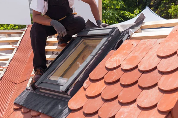 Kırmızı kiremit yeni bir çatı üzerinde mansard windows yüklemesi.