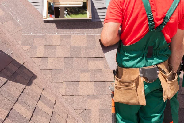 Roofer builder worker with bag of tools installing roofing shingles. — Stock Photo, Image