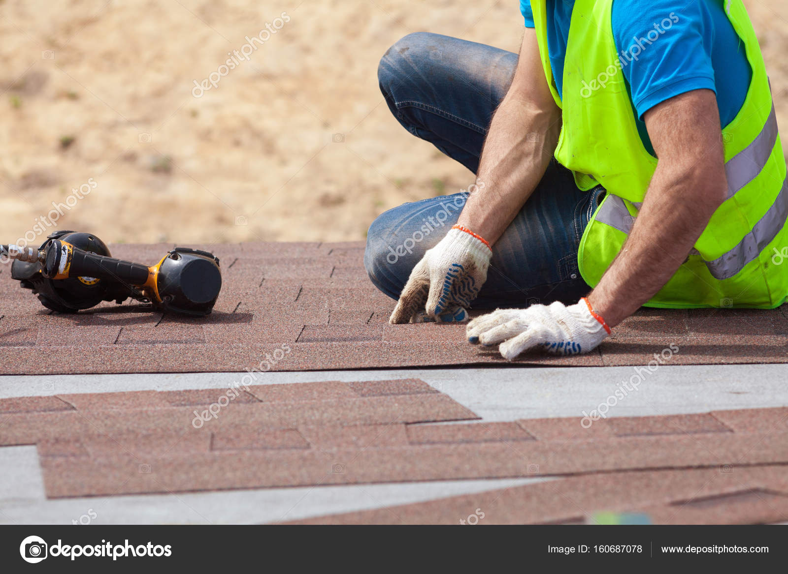 Roofer Builder Worker With Nail Installing Asphalt Shingles Or Roofer Builder Worker With Nail Installing Asphalt Shingles Or Bitumen Tiles On A New House Under