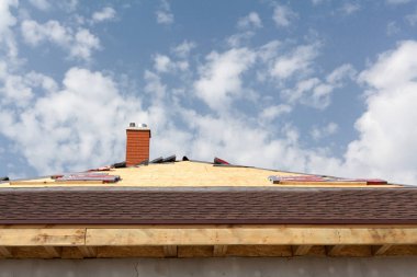 Yeni çerçeve ev yapım aşamasında. Çatı asfalt Zona, baca ve izolasyon malzemesi ile.