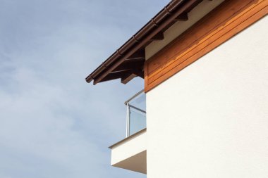 Kahverengi yağmur oluk, beyaz duvar ve balkon ile yeni ev.