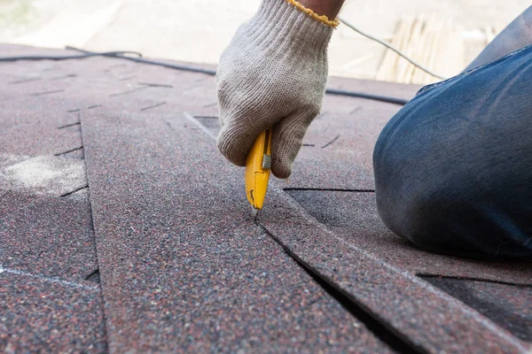 Roofer trabajador corta tejas en el techo . — Foto de Stock
