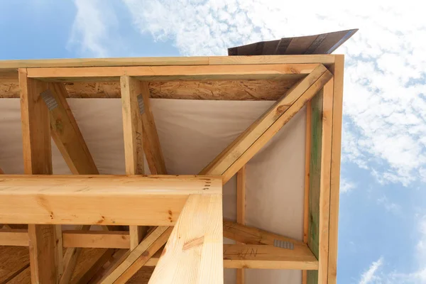 Hoek van huis met houten balken, dakranden en asfalt dakshingles. — Stockfoto