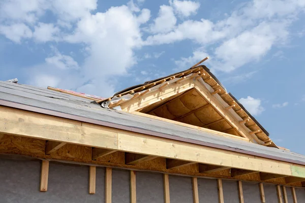 Nieuw frame huis in aanbouw. Dak met asfalt gordelroos, schoorsteen en isolatie materiaal in Zolder. — Stockfoto