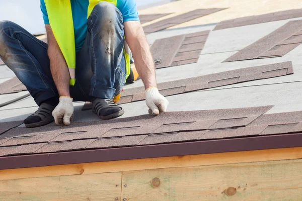 Trabajador constructor Roofer instalación de tejas de asfalto o baldosas de betún en una casa nueva en construcción . — Foto de Stock