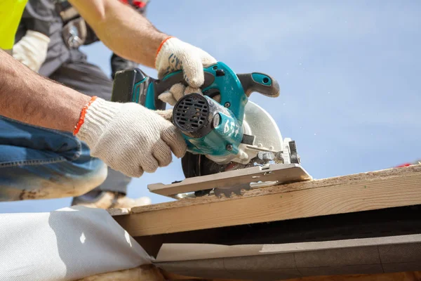 Het installeren van een dakraam. Bouwvakker Builder gebruik cirkelzaag te snijden een dakopening voor venster. — Stockfoto
