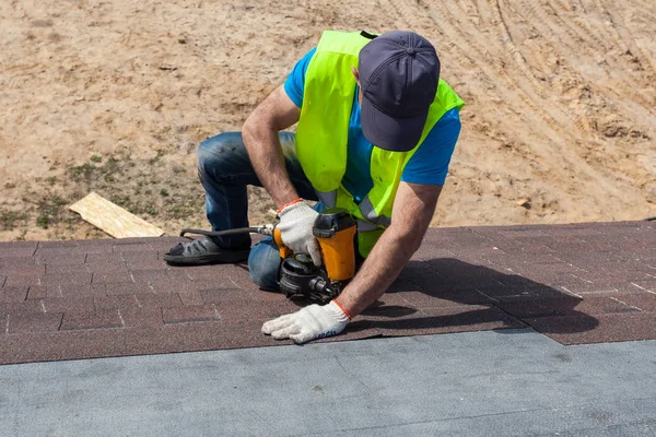 지붕 작성기 노동자 또는 건설 중인 새 집에 아스팔트 지붕 널 또는 암 갈색 타일 설치. — 스톡 사진