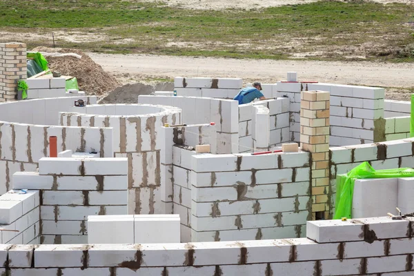 Operai costrittivi che costruiscono una rotonda con blocchi di cemento autoclavato aerato . — Foto Stock