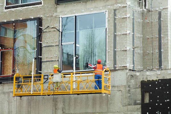 Zeměměřické velké staveniště. Zaměstnanci stavba nového domu, instalace oken, zateplování budov, balkon. Industrial Building Construction — Stock fotografie