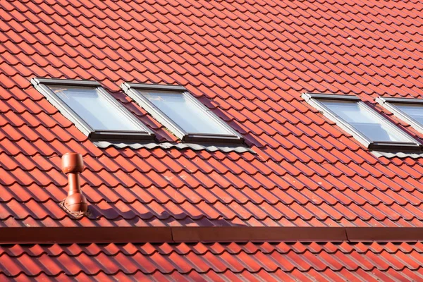 天窓と熱制御用換気パイプ新しい赤い金属屋根. — ストック写真