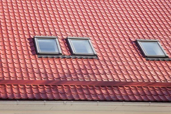 屋根裏部屋の窓 (天窓) と熱制御用換気パイプ新しい赤い金属屋根. — ストック写真