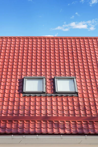 Techo de azulejos de metal rojo con nuevos huéspedes, ventanas de techo, tragaluces y protección del techo de Snow Board — Foto de Stock