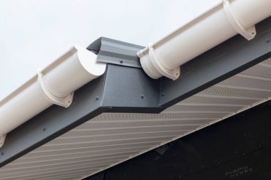 Panel ev yapımı yudumlayın. Yeni gri metal kiremit çatı ile beyaz yağmur oluk.