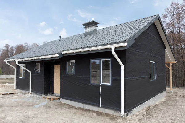 SIP panel house with new gray metal tile roof,white rain gutter and insulation.